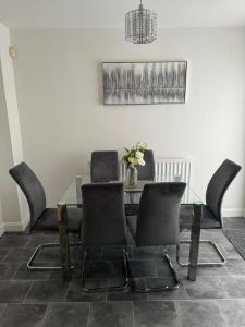 a dining room with a glass table and chairs at Manchester home near City Centre and City stadium in Manchester