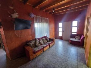 a living room with a couch and a tv at Cabañas con tinajas coronel in Coronel