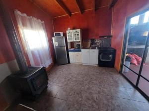 a kitchen with a refrigerator and a stove in it at Cabañas con tinajas coronel in Coronel