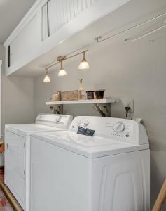 a white washing machine in a laundry room with lights at Austin Haus in Fredericksburg