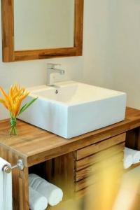 a white sink on a wooden counter with a mirror at Cosy studio - Trou-aux-Biches in Trou aux Biches