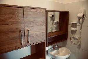 a bathroom with a sink and a wooden cabinet at BHB - ApartaHotel in Leticia