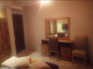 Zimmer mit einem Schreibtisch, einem Spiegel und einem Sofa in der Unterkunft FeWo Port Ghalib in Port Ghalib