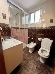 a bathroom with a toilet and a sink and a shower at ACOGEDOR PISO EN CULLERA JUNTO AL MAR in Cullera