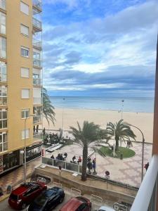 a view of the beach from a balcony of a building at ACOGEDOR PISO EN CULLERA JUNTO AL MAR in Cullera
