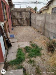 an empty yard with grass in front of a fence at Alojamiento económico a pasos del Jumbo! in La Serena