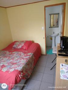 um pequeno quarto com uma cama e um lavatório em Alojamiento económico a pasos del Jumbo! em La Serena
