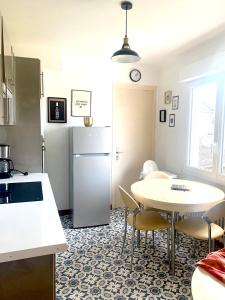 uma cozinha com uma mesa e um frigorífico em Maison familiale à 10 min du Mont Saint Michel em Pontorson