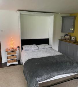 a bedroom with a large bed and a kitchen at The Lodge at Briar house in Long Melford