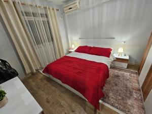 a bedroom with a large bed with a red blanket at Library Apartment by Bohem Rentals in Durrës