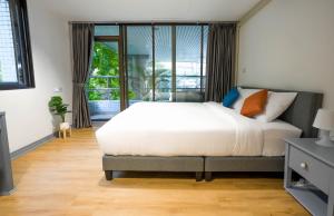 - une chambre avec un lit et une grande fenêtre dans l'établissement Cozy 2BR Apt in Central Bangkok 5 mins to BTS MattandCo, à Bangkok