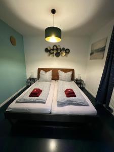 een slaapkamer met een bed met twee rode kussens erop bij Relaxen im Weindorf Mayschoß Fewo 3 in Mayschoß