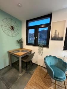 マイショスにあるRelaxen im Weindorf Mayschoß Fewo 3のテーブルと椅子、窓が備わる客室です。