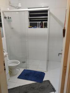a bathroom with a shower and a blue rug at Aphostel compartilhado gatinhos perças in Santos