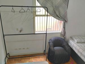 a room with a bean bag chair and a window at Aphostel compartilhado gatinhos perças in Santos