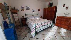 a bedroom with a bed and a dresser at Villa Soprana, casa per vacanze in Lipari +38 photos