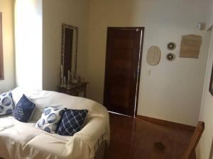 ein Wohnzimmer mit einem Sofa mit blauen und weißen Kissen in der Unterkunft Casa bem localizada e confortável em Cabo Frio in Cabo Frio