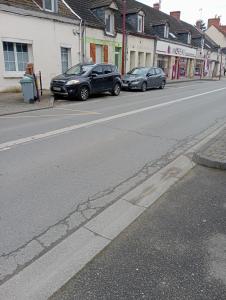 two cars parked on the side of a street at Le Cocooning in Vierzon