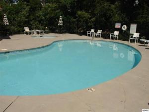 a large blue swimming pool with chairs and tables at Relaxing Condo on the River - NEW Air Hockey Table in Pigeon Forge