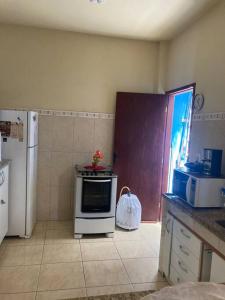 eine Küche mit einer Mikrowelle und einem Kühlschrank in der Unterkunft Casa bem localizada e confortável em Cabo Frio in Cabo Frio