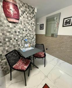 a table and chairs in a room with a wall at Cute Penthouse in Marsaskala