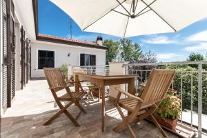 a patio with a wooden table and chairs and an umbrella at Oasi di Pace Sarzana in Luni +31 photos