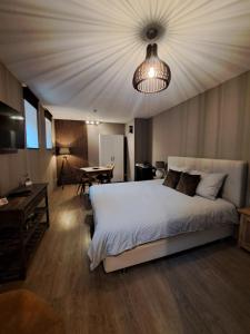 ein Schlafzimmer mit einem großen weißen Bett und einem Tisch in der Unterkunft B&B Fragaria in Hoogstraten