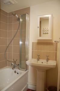 y baño con lavabo, ducha y bañera. en Bronhaul Cottage in Pennal, en Pennal