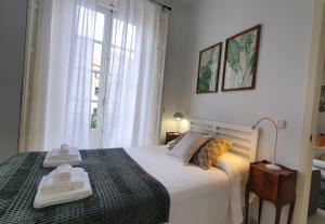 a bedroom with a bed with two towels on it at Magdalena Plaza City Center 1º in Seville