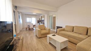sala de estar con sofá, sillas y mesa en Kuća za odmor LAURA, en Ražanac
