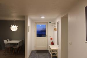 a hallway with a table and a door and a dining room at Laugarholt Apartment in Húsavík
