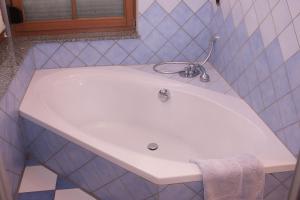 - białą umywalkę w wyłożonej niebieskimi kafelkami łazience w obiekcie Boardinghouse Schnaitheim w mieście Heidenheim an der Brenz