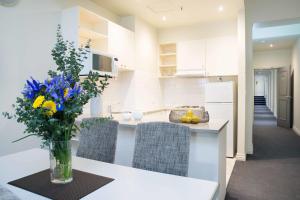 a kitchen with a vase of flowers on a counter at Hotel Collins in Melbourne