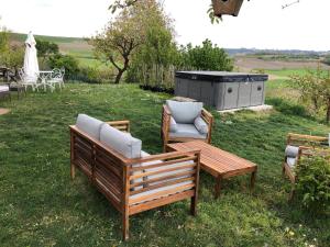 a couple of chairs and a table in the grass at Cascina Vicentini in Alfiano Natta