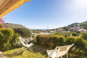 dos sillas blancas sentadas en la parte superior de un patio en La Vela Summer House - FREE WIFI - 700mt from the beach, en Costa Rei