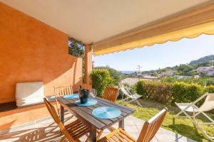 un tavolo e sedie in legno su un patio di La Vela Summer House - FREE WIFI - 700mt from the beach a Costa Rei