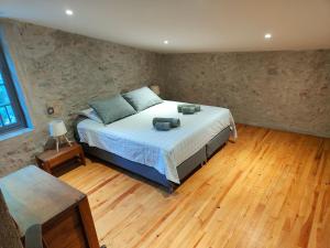 um quarto com uma cama e piso em madeira em Le Moulin de La Grave - Lagrasse em Lagrasse