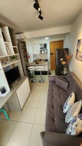 uma sala de estar com um sofá e uma cozinha em Confortável Studio no Park Sul próximo ao aeroporto em Brasília