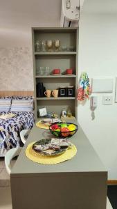 - un comptoir de cuisine avec 2 bols de fruits dans l'établissement Confortável Studio no Park Sul próximo ao aeroporto, à Brasilia