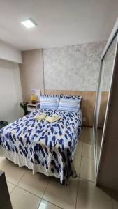 a bedroom with a bed with a blue and white comforter at Confortável Studio no Park Sul próximo ao aeroporto in Brasilia