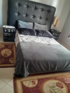 Schlafzimmer mit einem großen Bett mit einem schwarzen Kopfteil in der Unterkunft Ketama hachiche in Tlata Ketama