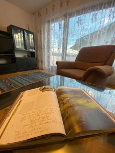 an open book sitting on a glass table with a chair at Spacious Haven with Homey Vibes near Ljubljana in Horjul