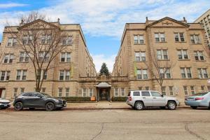 a large building with cars parked in front of it at Modern Minimalist Studio Haven - Bstone 105 and 108 rep in Chicago