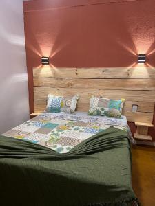 a bed with a wooden headboard and pillows on it at Pousada Recanto do Tucano in Cavalcante