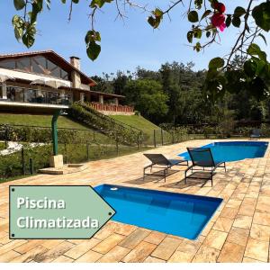 um resort com duas cadeiras e uma piscina em Pousada Gardenian em São Roque