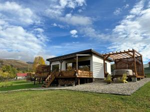 a tiny house in a field with a roof at Transalpina Tiny House - outdoor jacuzzi in Baia de Fier