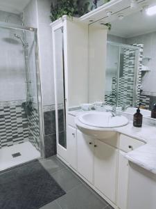 ein weißes Bad mit einem Waschbecken und einer Dusche in der Unterkunft Banda del Rio in Bueu