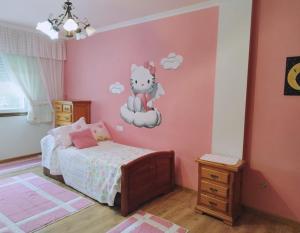 ein Kinderschlafzimmer mit einer Hello-Kitty-Wand in der Unterkunft Banda del Rio in Bueu