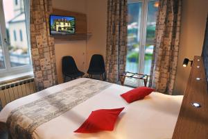 sypialnia z łóżkiem z czerwonymi poduszkami i telewizorem w obiekcie Hotel Restaurant Du Haut Du Roc w mieście Basse-sur-le-Rupt +45 zdjęć