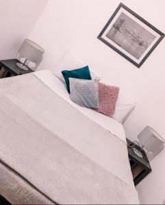 Una cama blanca con dos almohadas encima. en Pousada Casa Recanto da Serra, en Petrópolis